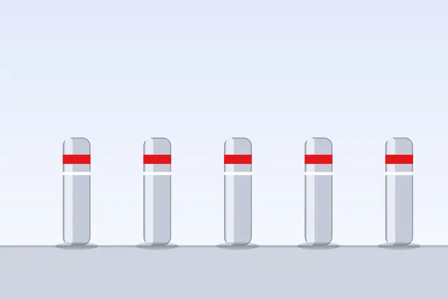 Row of steel bollards with reflective bands protecting a building entrance