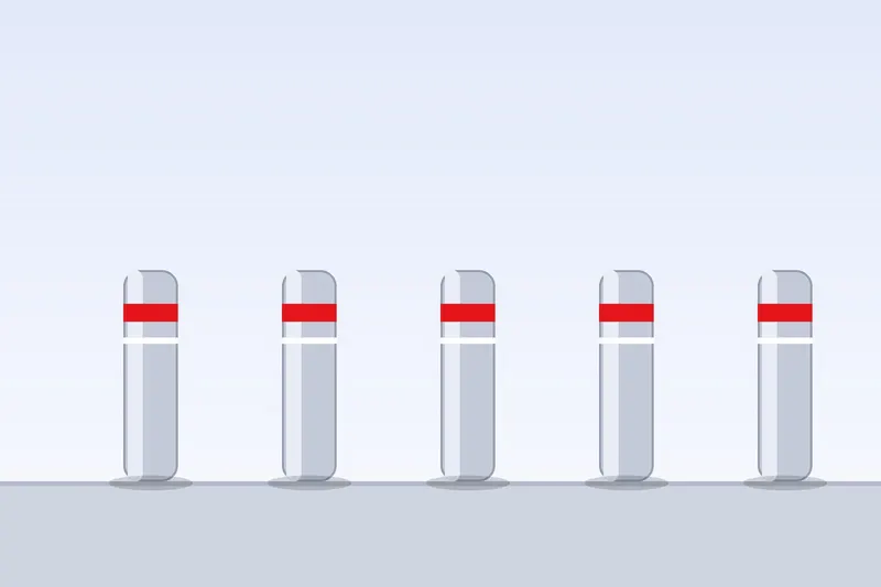 Row of steel bollards with reflective bands protecting a building entrance