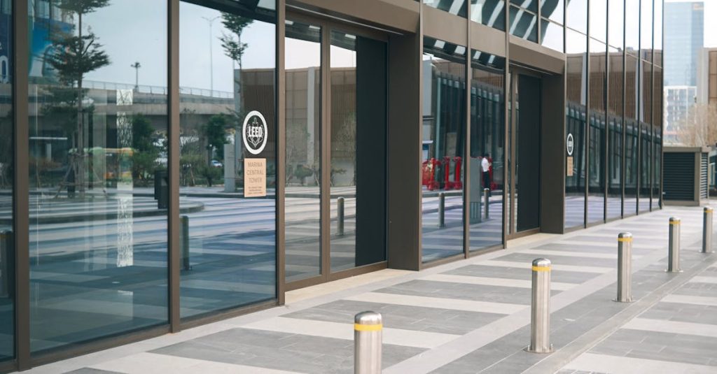 Sleek modern building exterior featuring glass windows and vertical pillars in a contemporary urban setting.